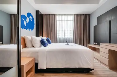 a hotel room with a large bed and a television at Kokotel Bangkok Dheva Thonglor in Bangkok