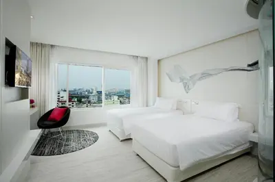 a hotel room with two beds and a window at Centara Watergate Pavilion Hotel Bangkok in Bangkok