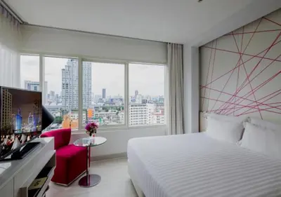 a hotel room with a bed and a large window at Centara Watergate Pavilion Hotel Bangkok in Bangkok