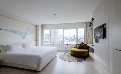 a bedroom with a white bed and a large window at Centara Watergate Pavilion Hotel Bangkok in Bangkok