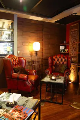 a living room with leather chairs and a table at The Fusion Suites in Bangkok