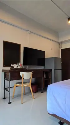 a bedroom with a desk with a television and a chair at J.K. Mansion in Bangkok
