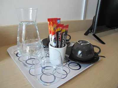 a tray with glasses and a vase on a table at J.K. Mansion in Bangkok
