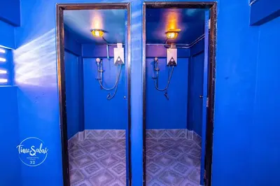 a bathroom with blue walls and two mirrors with lights at Time Sabai 32 in Bangkok