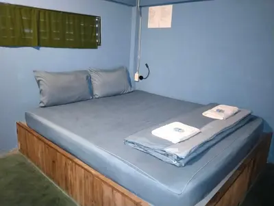 a bed in a room with two towels on it at Time Sabai 32 in Bangkok