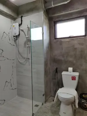 a bathroom with a toilet and a glass shower at THE HOG in Bangkok Yai