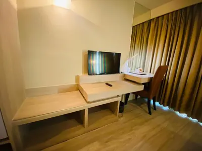a room with a desk with a television and a deskablish at Gold Orchid Bangkok Hotel in Bangkok