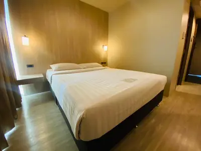 a bedroom with a large bed with white sheets at Gold Orchid Bangkok Hotel in Bangkok