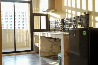 a kitchen with a counter and a sink and a window at Gold Orchid Bangkok Hotel in Bangkok
