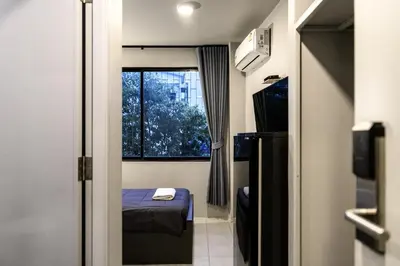 a small room with a bed and a window at Stay Wanglang in Bangkok