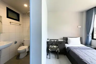 a bedroom with a bed and a sink and a toilet at Stay Wanglang in Bangkok