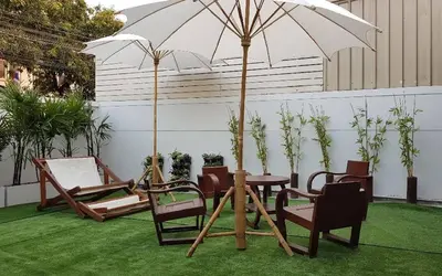 a patio with a table and chairs and an umbrella at 138 White Villa in Bangkok