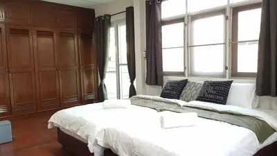a bedroom with a large white bed and windows at 138 White Villa in Bangkok