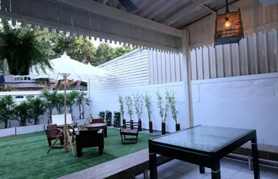 a patio with a table and chairs and plants at 138 White Villa in Bangkok