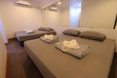 two beds in a room with towels on them at Baan33 check in by yourself code inbox 4fl behind Amazon cafe in Bangkok