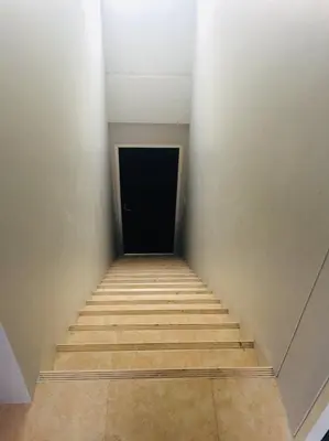 a stairway with a black door in a room at Baan33 check in by yourself code inbox 4fl behind Amazon cafe in Bangkok