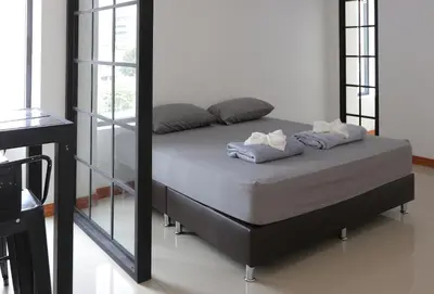 a bed in a room with a mirror at Baan33 check in by yourself code inbox 4fl behind Amazon cafe in Bangkok