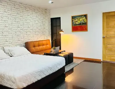 a bedroom with a bed and a brick wall at Baan33 check in by yourself code inbox 4fl behind Amazon cafe in Bangkok