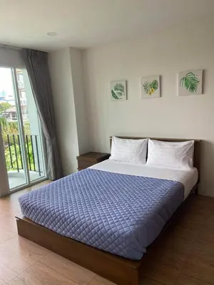 a bedroom with a large bed with a blue comforter at TEAK VILLA in Bangna