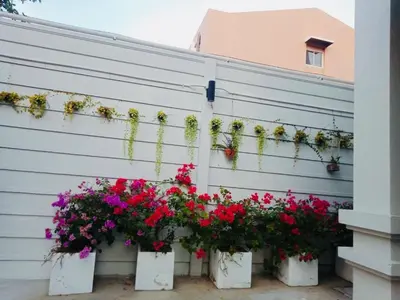 a fence with flowers in white containers on it at TEAK VILLA in Bangna