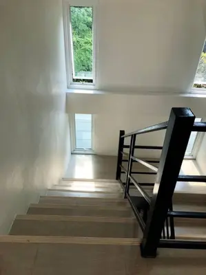 a staircase in a room with two windows at TEAK VILLA in Bangna