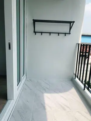 a room with white walls and a balcony with windows at TEAK VILLA in Bangna