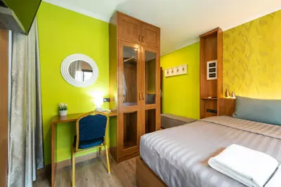 a bedroom with a bed and a desk and a chair at Tepbunthom Hostel in Bangkok