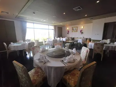 a dining room with white tables and chairs and a table with napkins at LEE PLACE HOTEL in Bangkok