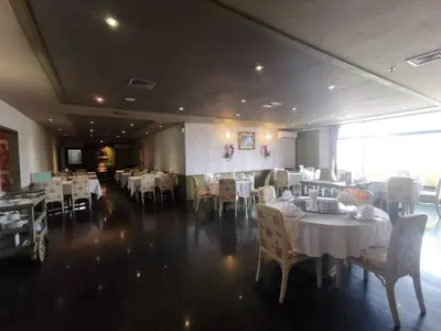 a dining room with tables and chairs with white tablecloths at LEE PLACE HOTEL in Bangkok