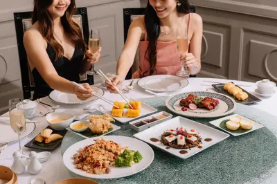 two women sitting at a table with plates of food at InterContinental Bangkok by IHG in Bangkok