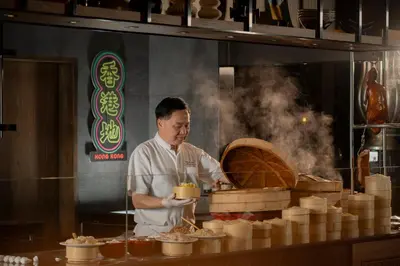 a chef preparing food in a restaurant kitchen at InterContinental Bangkok by IHG in Bangkok