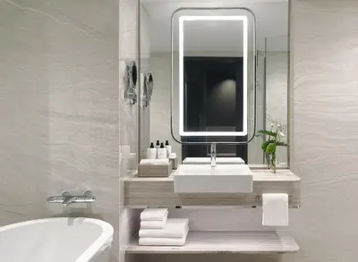 a bathroom with a sink and a mirror and a tub at InterContinental Bangkok by IHG in Bangkok