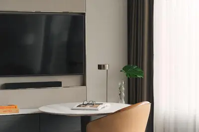 a room with a table with a tv and a chair at InterContinental Bangkok by IHG in Bangkok