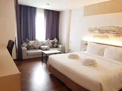 a hotel room with a large bed and a couch at Parinda Hotel in Bangkok
