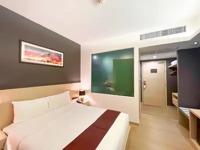 a bedroom with a white bed and a green wall at iCheck inn Nana by Aspira in Bangkok