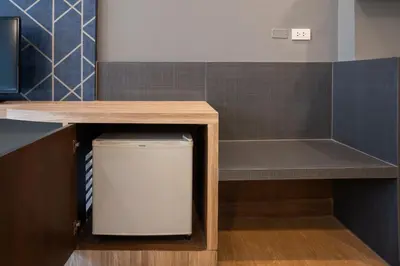 a small cabinet with a table and a trash can at iCheck inn Gems Center Silom in Bangkok