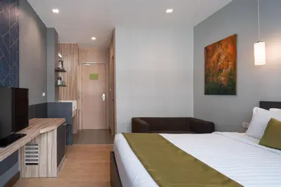 a hotel room with a bed and a television at iCheck inn Gems Center Silom in Bangkok