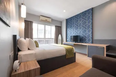 a hotel room with a bed and a tv at iCheck inn Gems Center Silom in Bangkok