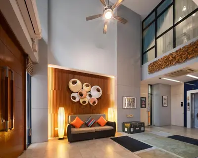 a lobby with a couch and plates on the wall at iCheck inn Gems Center Silom in Bangkok