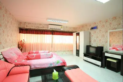 a bedroom with a pink bed and a television at Deluxe at Popular Condo in Bangkok