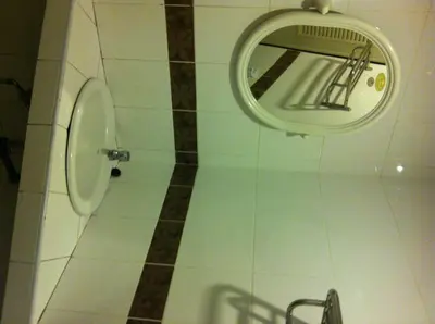 a bathroom with a mirror and a toilet at Orchid Place in Bangkok