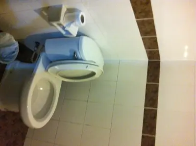 a bathroom with a toilet with a roll of toilet paper at Orchid Place in Bangkok
