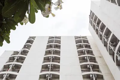 a tall white building with balconies on it at The Legacy Convention Hotel in Nonthaburi
