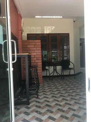 a room with a table and chairs and a brick wall at Orchid House in Bangkok