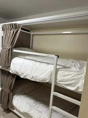 a bunk bed with a ladder in a room at Orchid House in Bangkok