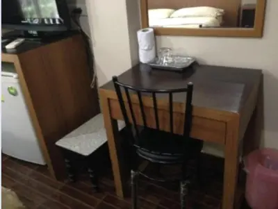 a wooden desk with a chair and a mirror at White Orchid Inn II in Bangkok