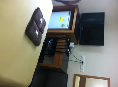 a kitchen with a counter with a tv on the wall at White Orchid Inn II in Bangkok