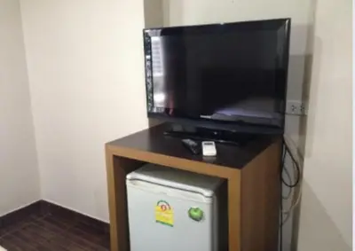 a flat screen tv sitting on top of a small refrigerator at White Orchid Inn I in Bangkok