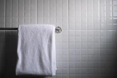 a white towel hanging on a towel rack in a bathroom at Oblique Apartment - ออฟบลิค อพาร์ทเมนท์ in Nonthaburi