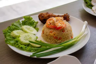 a plate of food with rice and vegetables on a table at Tango Vibrant Living Hotel - SHA Extra Plus in Bangkok